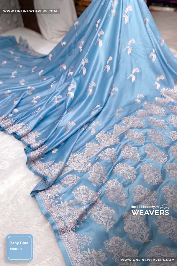 Light Baby Blue Banarasi silk saree with intricate gold zari rose floral woven work, draped elegantly to showcase its border and pattern. "OnlineWeavers' branding