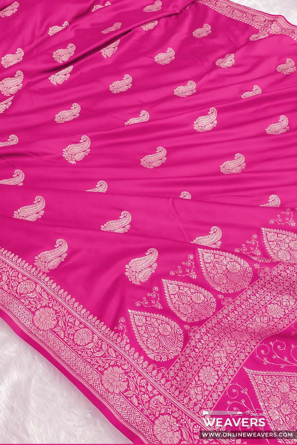 A bright pink mashru Banarasi silk saree with intricate gold zari paisley and floral motifs, featuring a wide decorative border.