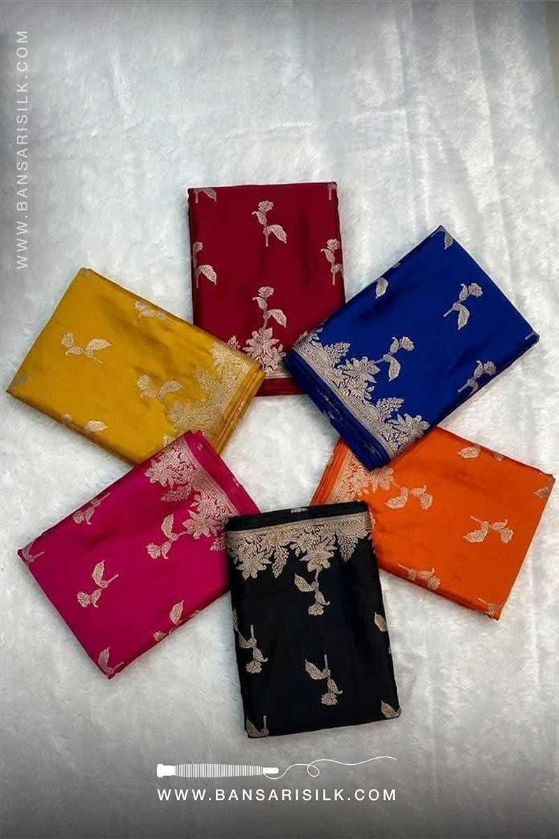 Set of colorful mashru silk scarves with floral patterns on a textured surface, branded 'Bansari Silk'.